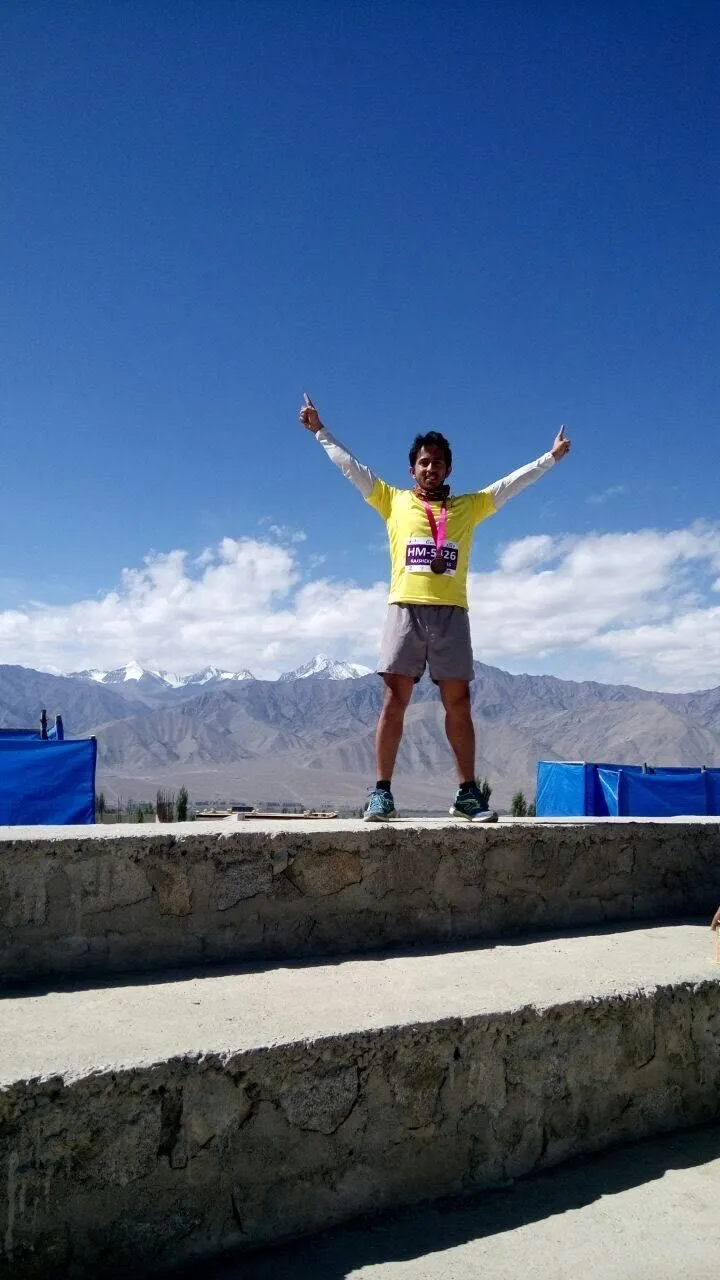 Raj with arms raised on a mountain trek