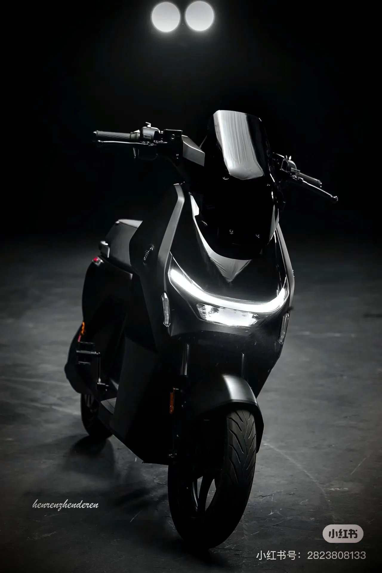 The Ninebot Dz, front on, lights glowing in a dark studio